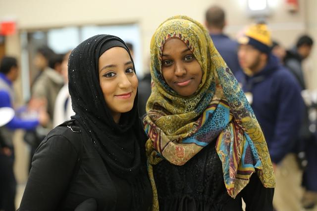 两个戴着头巾的留学生站在一起，面带微笑