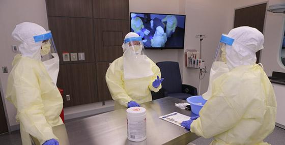 实验室里的研究人员穿着长袍，戴着口罩